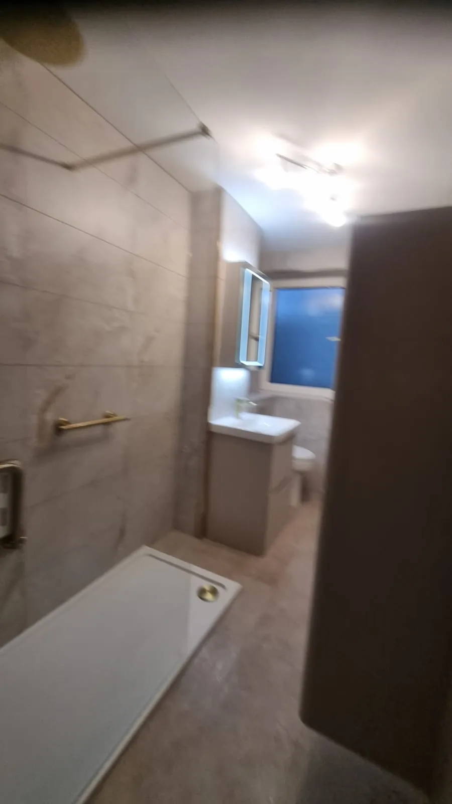Narrow shower room with brass fittings and tall storage